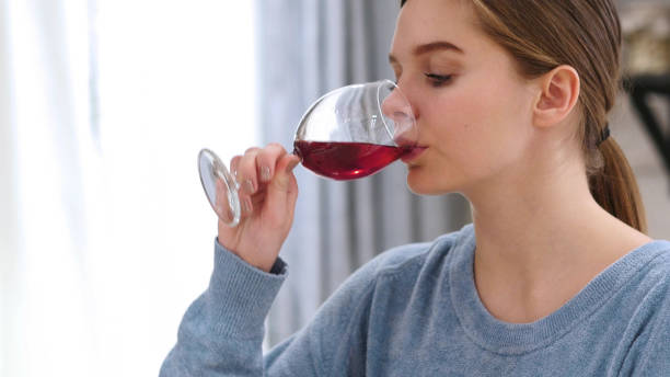 istock Beautiful Woman Drinking Wine at Home 1077314826