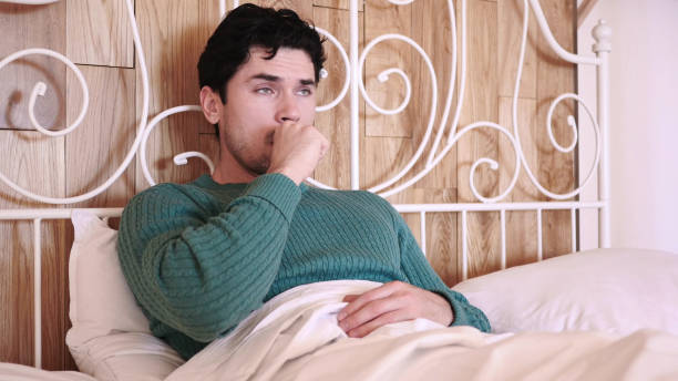 istock Coughing Sick Man in Bed at Night, Throat Infection 1077315006