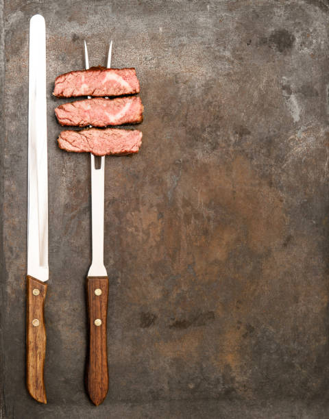 istock Grilled beef meat fork knife Food background 1077316078
