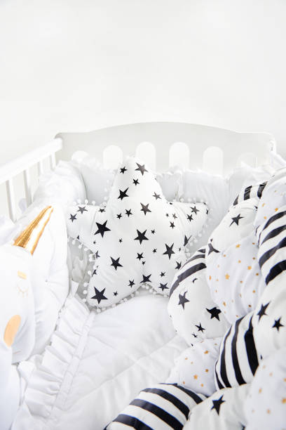 istock Cozy baby cot with star shaped cushion and patchwork comforter blanket with stars and black stripes 1077329568