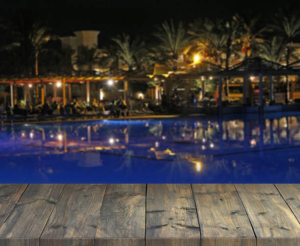 tablón de madera vacía con vista de noche de fiesta tropical. tapa de tabla con resort - 11305 fotografías e imágenes de stock