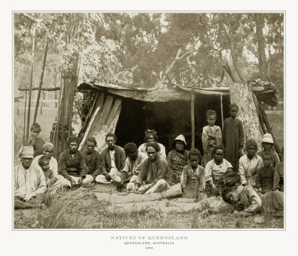 Dani Village, Baliem Valley,  Irian Jaya Province, Indonesian New Guinea aa July 16, 2009:  New Guinean natives Dugum Dani of a tribe sit on a bench in Village with the leader of a tribe Yali Mabel. Kotekas for sale.