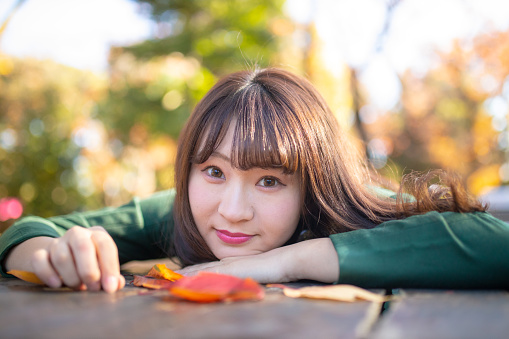 Portrait of young woman resting in autumn forest