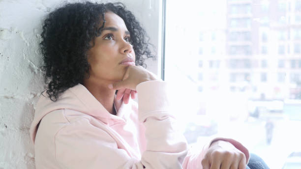 istock Young African Woman Thinking and Brainstorming, Sitting at Window 1077357706