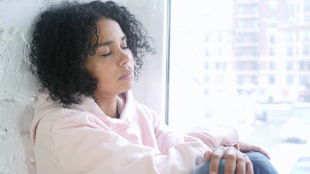 istock Young African Woman Sleeping, Sitting at Window 1077357868