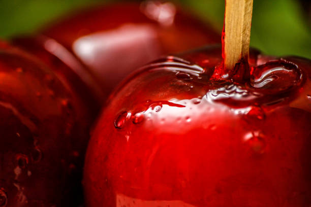 bonbon rouge ou pomme caramel avec vigne liane verte en arrière-plan - pomme d'amour photos et images de collection