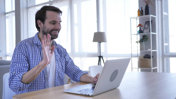 istock Online Video Chat on Laptop at Work by Casual Beard Man 1077360034