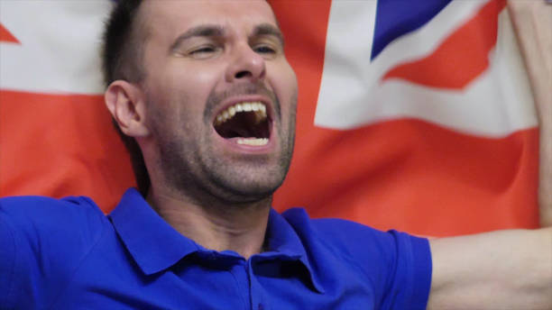 istock British Fan Celebrating while holding the British Flag in Slow Motion 1077360196