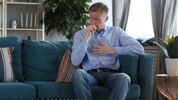 istock Sick Man Sitting and Coughing, Cough Infection 1077362514