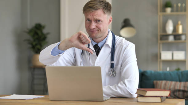 istock Thumbs Down by Upset Doctor Looking at Camera 1077363372