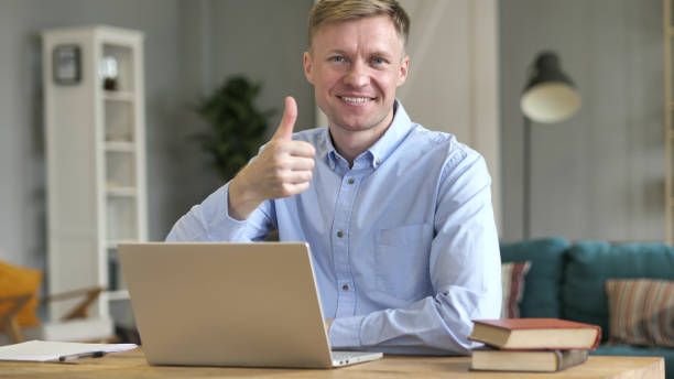 istock Thumbs Up by Businessman Looking at Camera at Work 1077363908