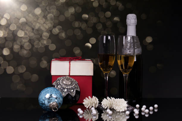 istock Two glasses with champagne, gift and Christmas ornaments 1077368702