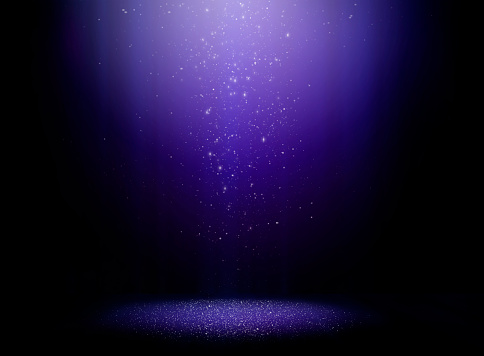 Stage with one light beam and sparkly dust falling from above