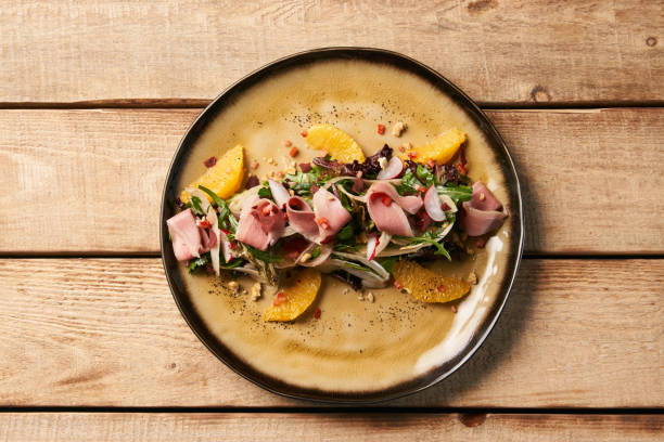 istock Smoked duck breast with fresh vegetable salad on wooden table ba 1077373930