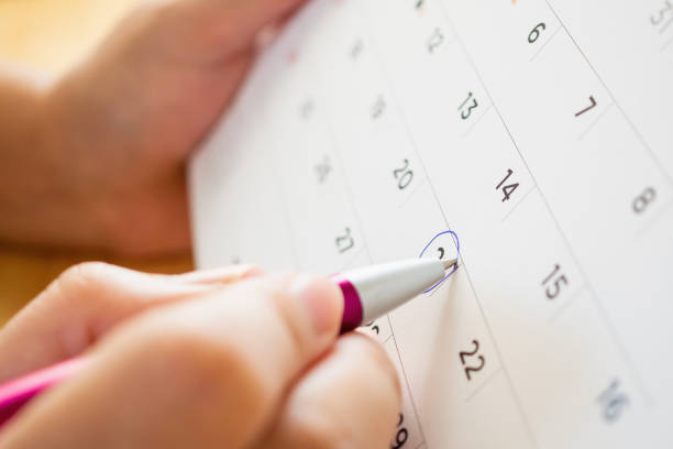 istock calendar page with female hand holding pen 1077400896