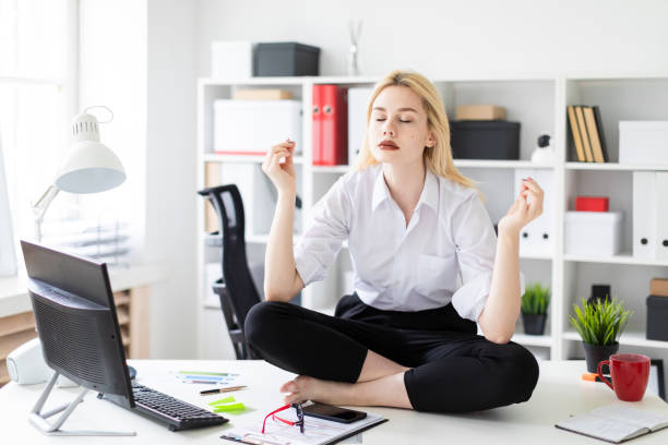 istock A young girl sitting on a table in the office. 1077401154