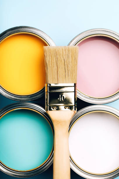 istock Brush with wooden handle on open cans on blue pastel background. 1077401638