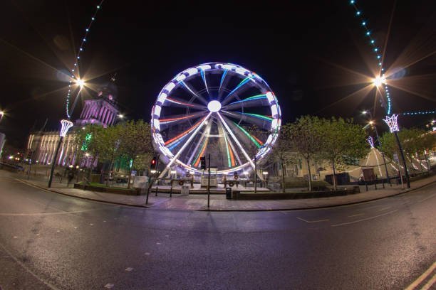 foto de longa exposição grande angular da leeds natal roda gigante que está do lado de fora da prefeitura de leeds - leeds england leeds town hall night uk - fotografias e filmes do acervo