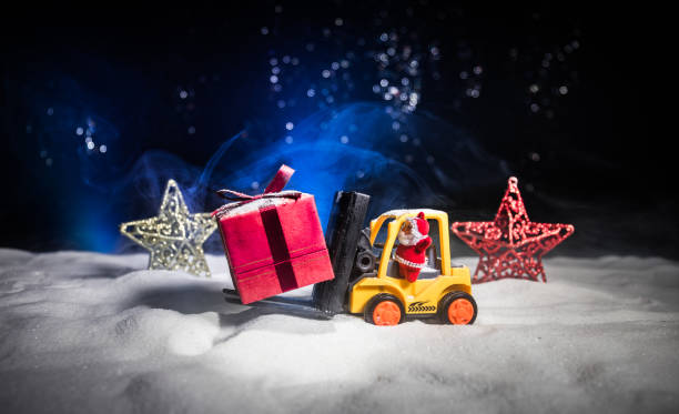 istock Miniature Gift Box by Forklift Machine on snow ,Determined Image for Christmas Holiday and Happy New Year Gift Celebration concept. 1077417844