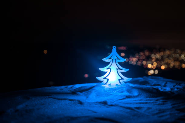 Christmas decorations. Fir tree standing on snow with beautiful holiday decorated background and traditional holiday attributes. Selective focus. Empty space for your text