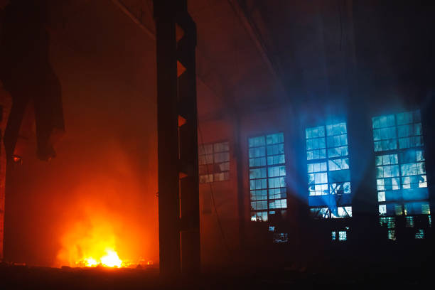 Fire in factory building at night. Burned by fire industrial warehouse, toned