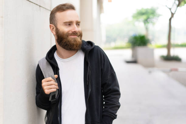 istock Relaxed young bearded man walking on street 1077423866