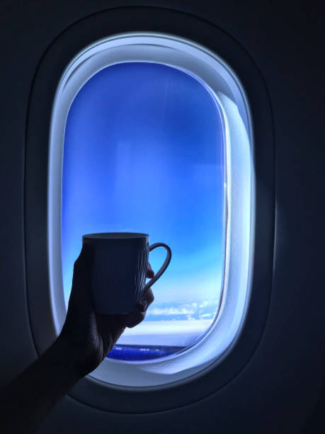 istock Hand holding a coffee cup in front of an airplane window 1077423938