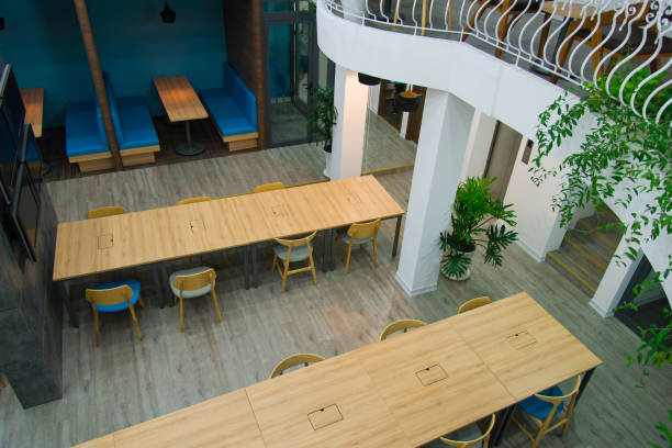 istock Top view of open space with wooden tables and chairs 1077431268