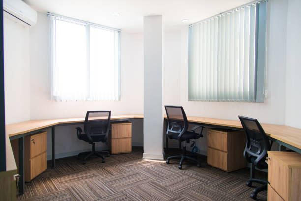 istock Small office with wooden table and stands near wall 1077431270