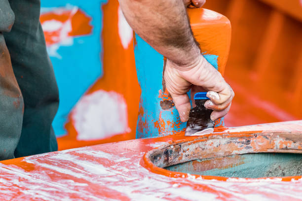 istock A man - worker using spatulas to repair with plaster patch a boat before paint. 1077438568