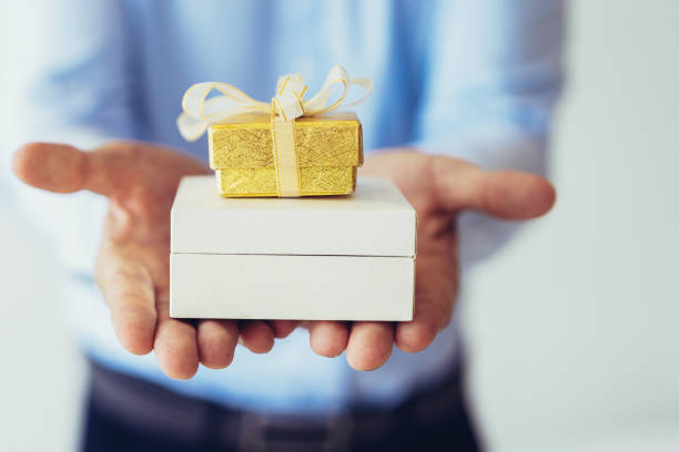 istock Closeup of man holding two small gift boxes on palms 1077440252