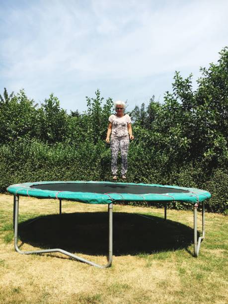 istock Woman Levitating Over Trampoline Against Plants 1077455306
