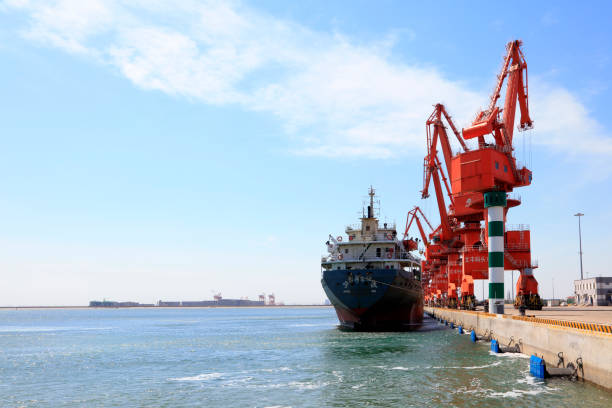 istock Caofeidian - April 17: cargo ships and tower crane on the freight terminal, on April 17, 2016, caofeidian, hebei province, China 1077459066