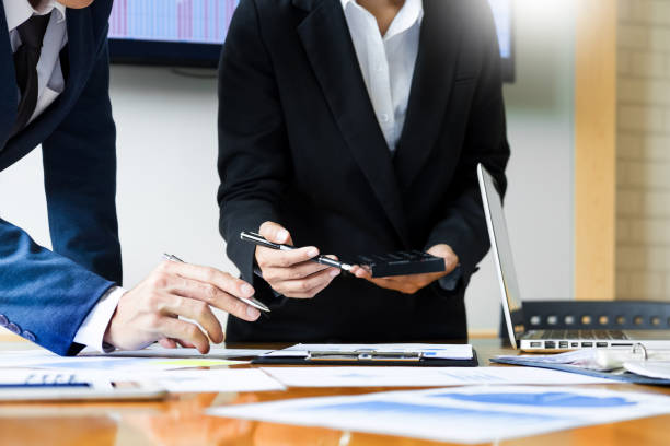 istock Midsection Of Colleagues Working At Desk In Office 1077462614