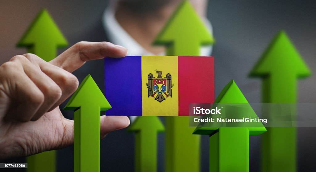 Nation Growth Concept, Green Up Arrows - Businessman Holding Card of Moldova Flag Abstract Stock Photo