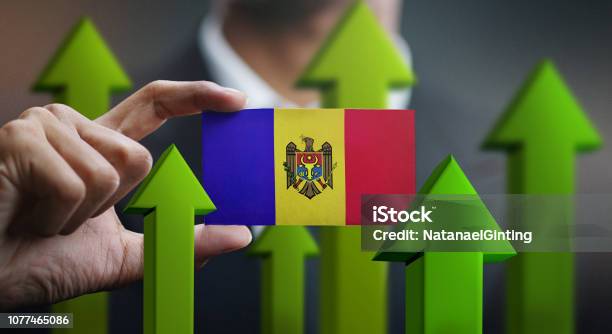 Nation Growth Concept Green Up Arrows Businessman Holding Card Of Moldova Flag Stock Photo - Download Image Now