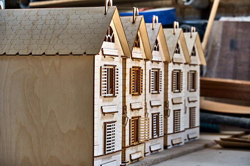 Toy wooden houses with opening and closure shutters. The constructor carved from plywood for children.