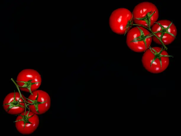 fresh red tomatoes in top right and bottom left top view black background