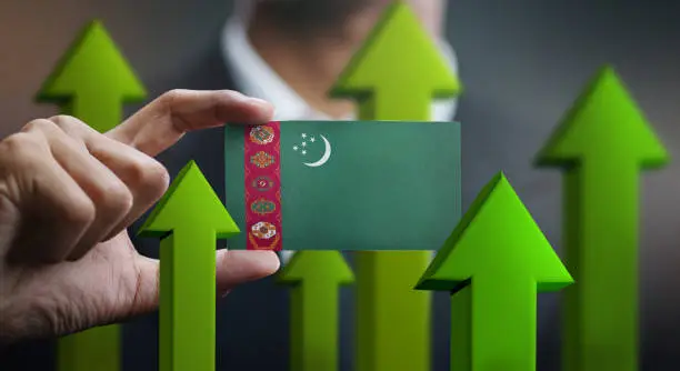 Photo of Nation Growth Concept, Green Up Arrows - Businessman Holding Card of Turkmenistan Flag