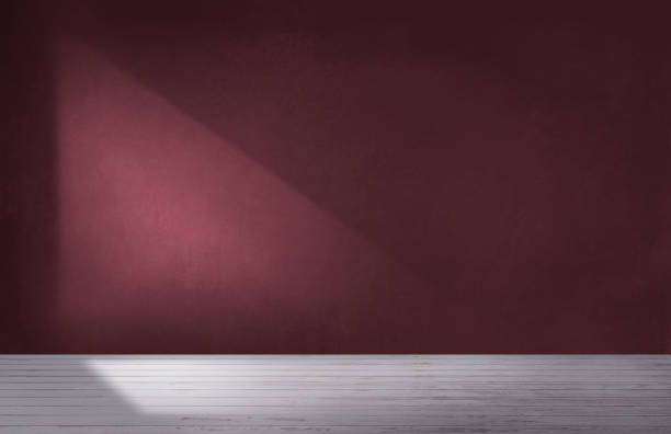 Burgundy red wall in an empty room with concrete floor