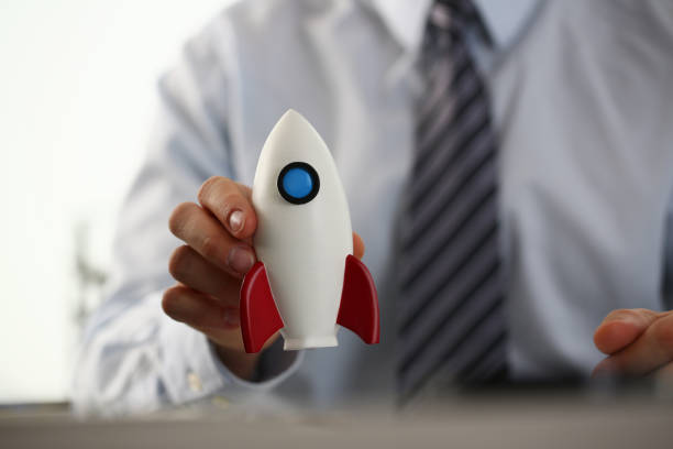 istock Businessman in suit hold white rockrt in hand 1077481710