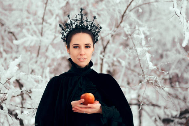 istock Evil Queen with Poisoned Apple in Winter Wonderland 1077492080