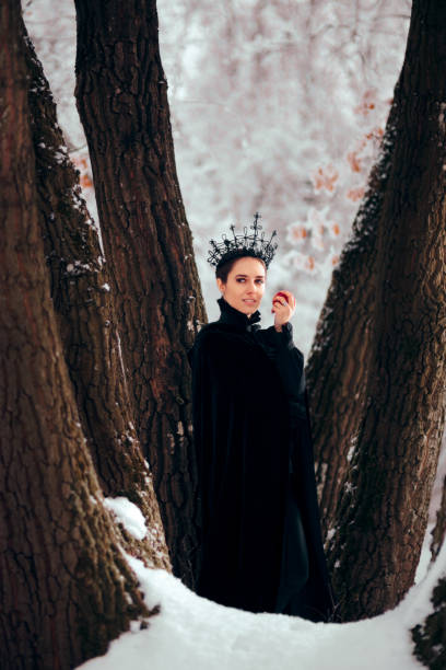 istock Evil Queen with Poisoned Apple in Winter Wonderland 1077492106