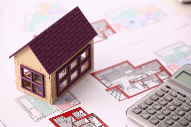 istock Small miniature house stands on drawing 1077497016