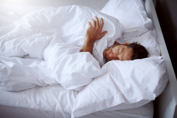 He has no problems with falling in sleep Cropped shot of a middle-aged man sleeping peacefully in his bed man sleeping on bed stock pictures, royalty-free photos & images