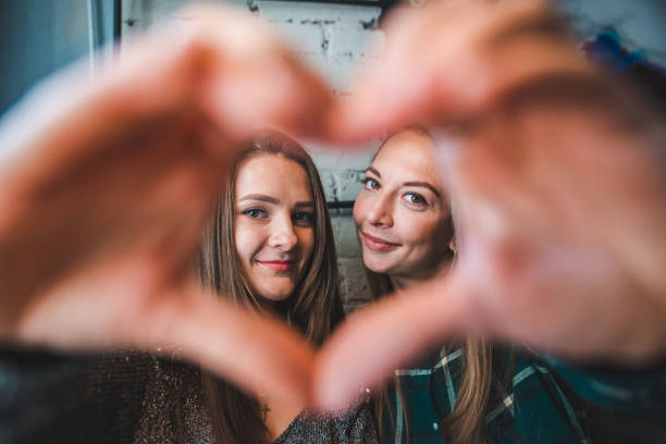 istock two girlfriends making frame with their hands to make picture 1077505482