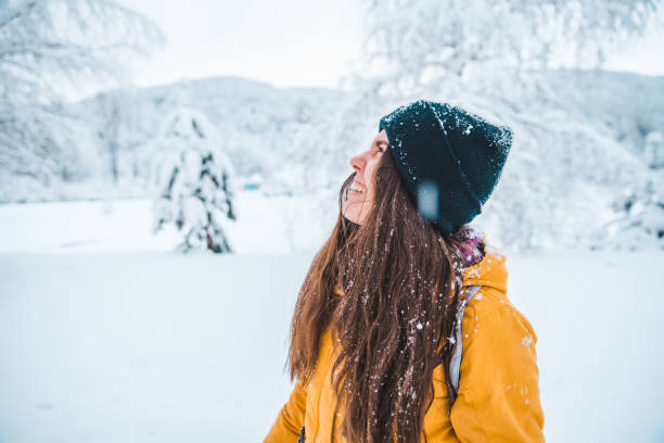istock smiling woman portrait outdoors snow on hat 1077505526
