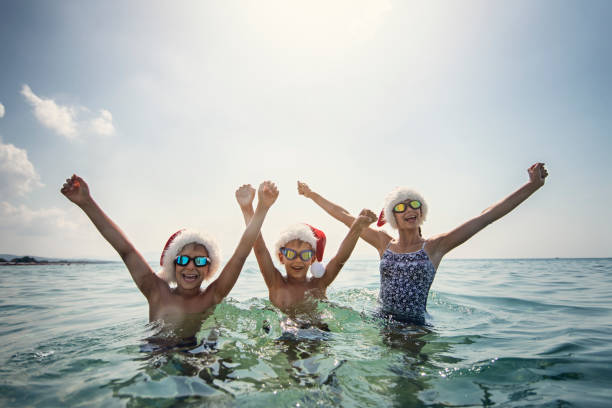 istock Kids cheering in sea on summer Christmas 1077510736