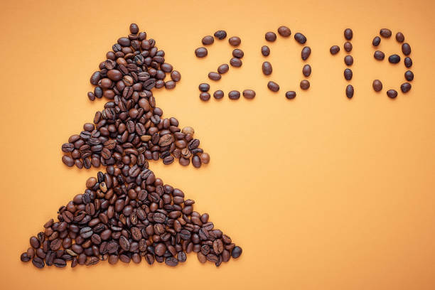 istock Christmas tree of coffee beans on orange background 1077514406