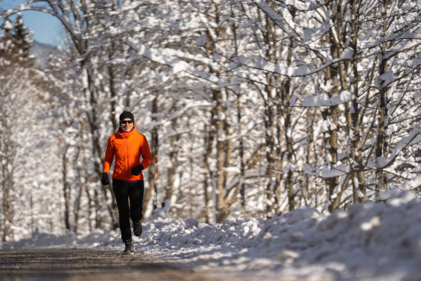 in forma donna fiduciosa emozioni positive jogging nel paesaggio invernale su strada - inspiration cold motivation passion foto e immagini stock